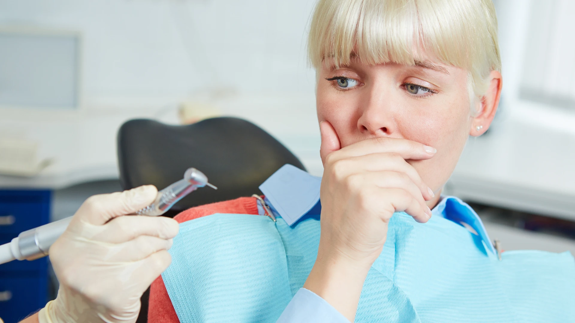 Woman looking nervous at dental clinic, representing dental anxiety