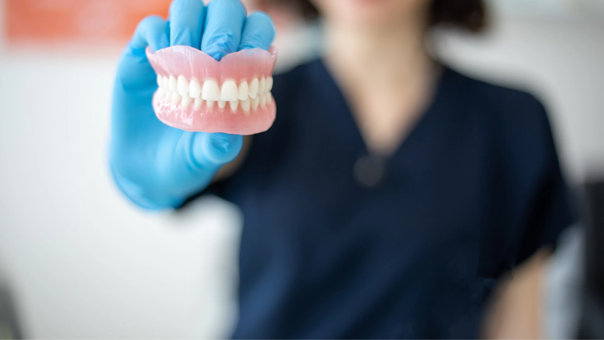 Full set of upper and lower dentures on pink dental base model
